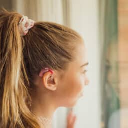 Teen girl wearing hearing aids at home