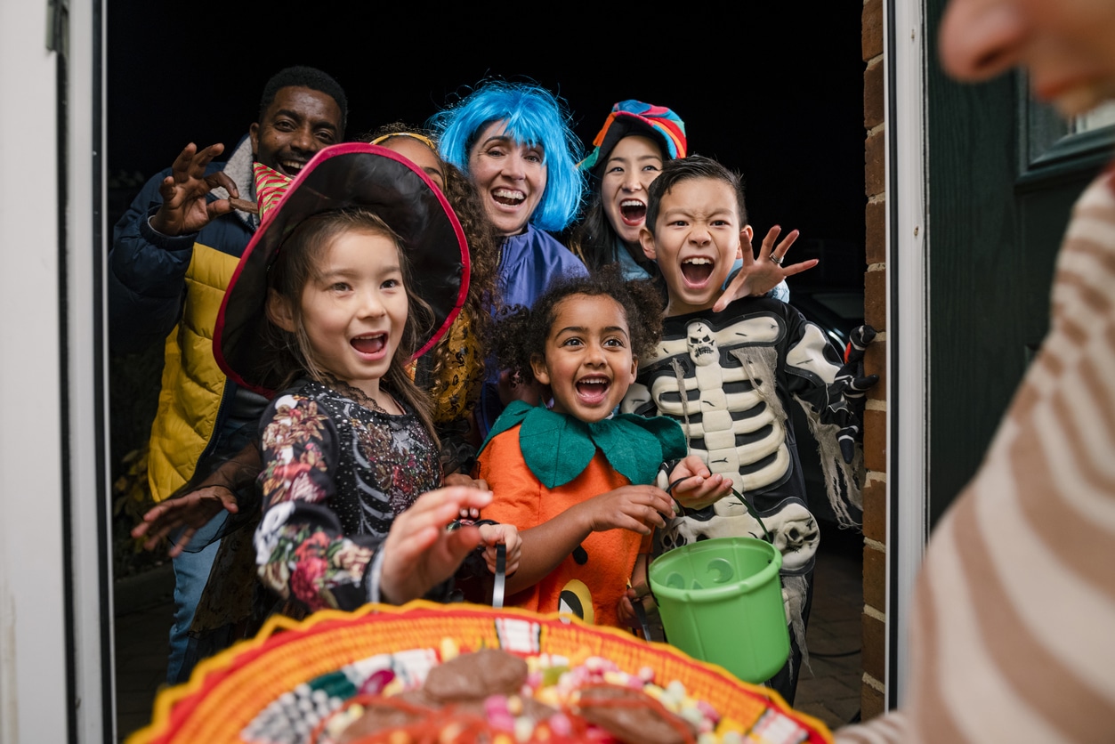 Kids and adults in costume trick or treating.