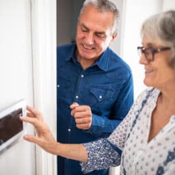 Older couple setting the alarm at home